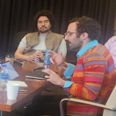 Greg Valdespino speaking and David Sanchez-Greenwood listening