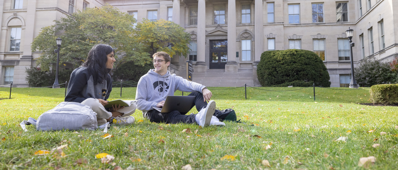 students sitting on lawn in front of Schaeffer Hall studying