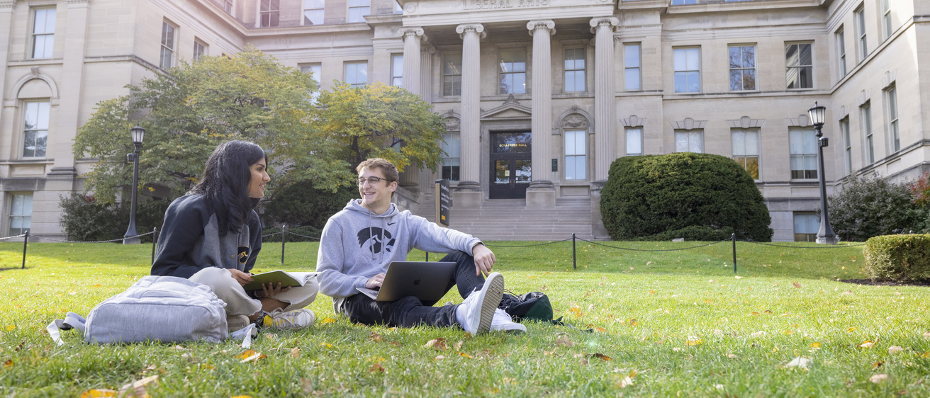 students sitting on lawn in front of Schaeffer Hall studying