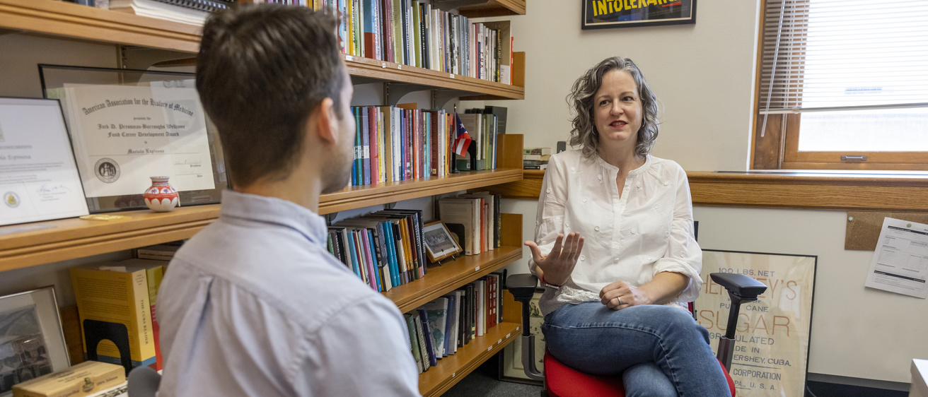 Faculty Mariola Espinosa meeting with a grad student in her office