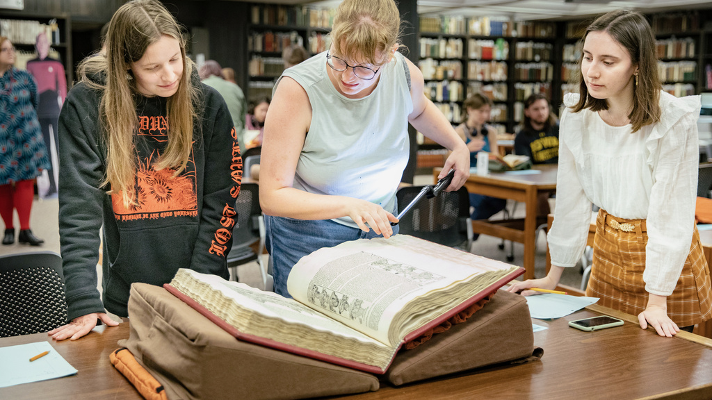Two students examine a book from UI Special Collections during a Department of History class